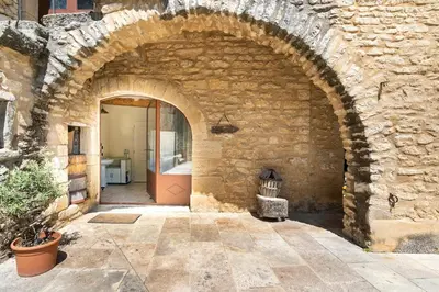 an entrance to a stone building with an archway at Cabane Perchée avec Jacuzzi, au Coeur du Luberon in Oppède