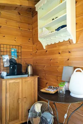 a kitchen with wooden walls and a fan at Cabane Perchée avec Jacuzzi, au Coeur du Luberon in Oppède