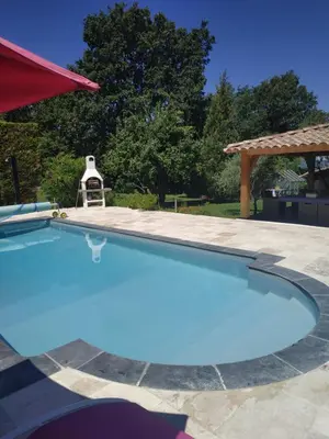 a large blue swimming pool with a gazebo at AU BONHEUR et LIBERTÉ in Meyrargues
