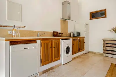 a kitchen with a washer and dryer in it at Gite dans un Mas Provençal avec Jacuzzi in Oppède