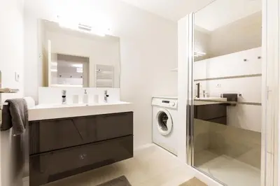 a bathroom with a sink and a washing machine at Le Jardinet de la Cathédrale in Aix-en-Provence