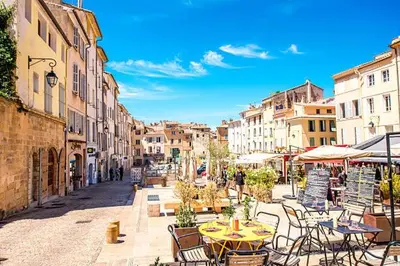 a city street with tables and chairs and buildings at Le Jardinet de la Cathédrale in Aix-en-Provence