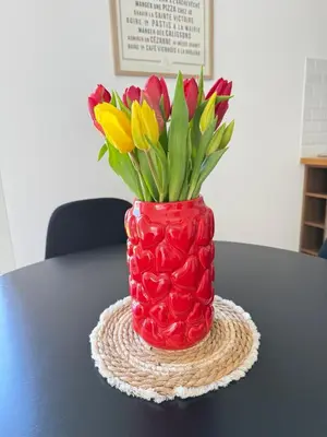 a red vase with flowers in it on a table at Duplex indépendant avec clim et parking St Donat in Aix-en-Provence