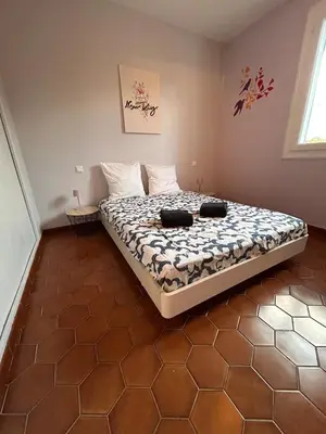 a bedroom with a bed with two black shoes on it at Le Paradis au centre du Vaucluse in Saumane-de-Vaucluse