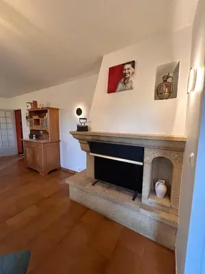 a living room with a stone fireplace in a house at Le Paradis au centre du Vaucluse in Saumane-de-Vaucluse