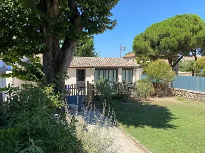 a white house with a tree in the yard at Vacances face au Luberon in Robion en Luberon