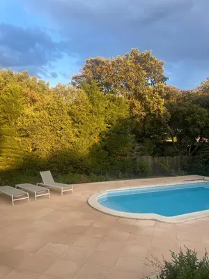 a swimming pool with two lounge chairs next to it at La maison du bon remède in Mazan