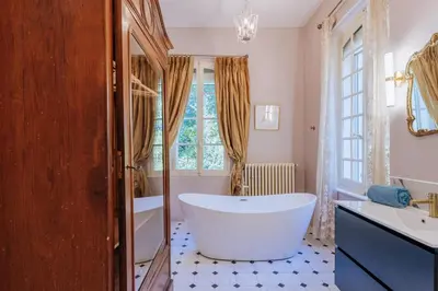 a bathroom with a large tub and a window at Chateau du Jonquier in Mazan