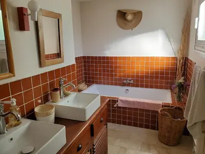 a bathroom with a tub and a sink and a mirror at Charming Famillial House with pedestrian access to Village in Venelles
