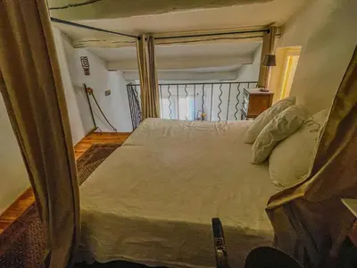 a bedroom with a large bed in a room at Maison de charme au coeur du village de Gordes in Gordes