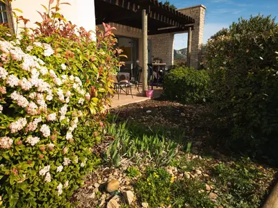 a garden with flowers in front of a house at Appartement au coeur du Golf de Saumane in Saumane-de-Vaucluse