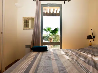 a bedroom with a bed in front of a window at Appartement au coeur du Golf de Saumane in Saumane-de-Vaucluse
