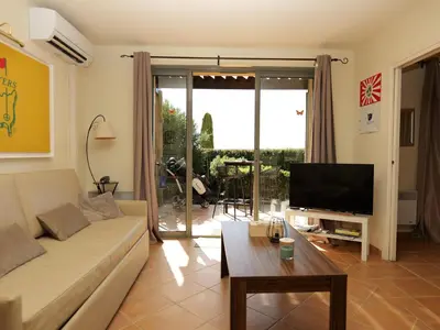 a living room with a couch and a tv at Appartement au coeur du Golf de Saumane in Saumane-de-Vaucluse