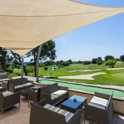 a patio with a view of a golf course at Appartement au coeur du Golf de Saumane in Saumane-de-Vaucluse