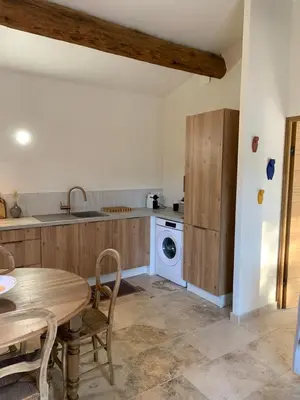 a kitchen with a table and a washing machine at Mazet LEAJO 2 in Eygalières