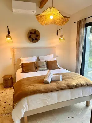 a bedroom with a large white bed with brown pillows at Mazet LEAJO 2 in Eygalières