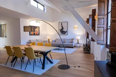 a living room with a dining room table and yellow chairs at Appartement centre Aix Terrace et ascenseur in Aix-en-Provence