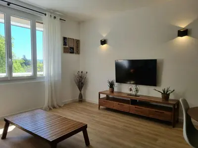 a living room with a flat screen tv on a wall at Bright T2 - parking - AC in Aix-en-Provence