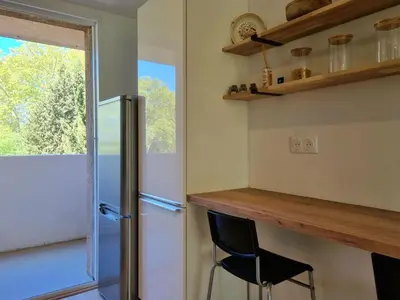 a kitchen with a counter and a refrigerator at Bright T2 - parking - AC in Aix-en-Provence