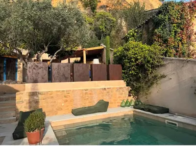 a swimming pool in a backyard with a fence and trees at CaBaNa 52 La chambre Proche Lourmarin in Cadenet