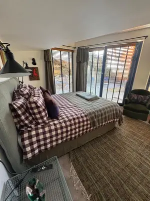 a bedroom with a bed and a large window at CaBaNa 52 La chambre Proche Lourmarin in Cadenet