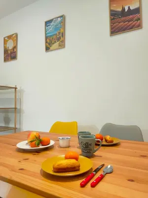 a wooden table with plates of food and a cup of coffee at Joli appartement Urbain in Cavaillon
