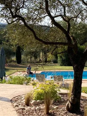 two people sitting in chairs near a swimming pool at Beautiful Property Isle-sur-la-Sorgue in LʼIsle-sur-la-Sorgue