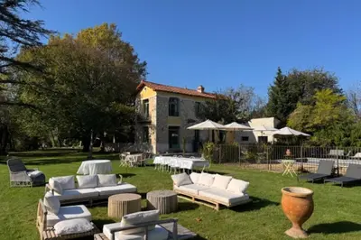 a yard with white couches and chairs and a house at Magnificent Bourgeois House Renovated with Elegance and Art Deco Style in Le Thor