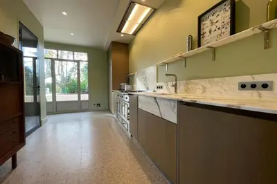 a large kitchen with green walls and a large counter top at Magnificent Bourgeois House Renovated with Elegance and Art Deco Style in Le Thor
