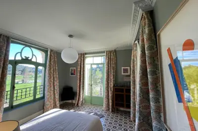 a bedroom with a bed and a large window at Magnificent Bourgeois House Renovated with Elegance and Art Deco Style in Le Thor