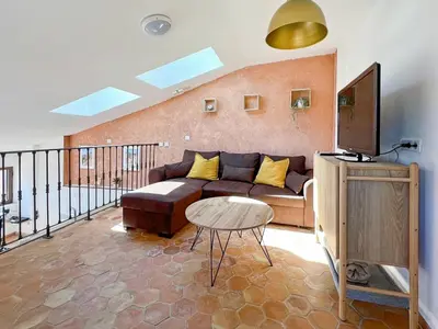 a living room with a couch and a tv at Duplex centre de Roussillon avec Climatisation et vue in Roussillon