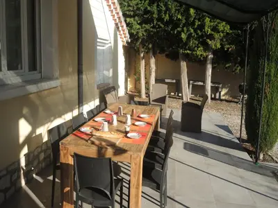 a wooden table and chairs on a patio at Holiday Home in L'Isle-sur-la-Sorgue with Pool in LʼIsle-sur-la-Sorgue