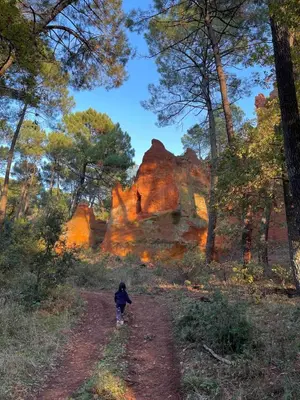 a child walking down a dirt road in a forest at Apartment Roussillon village Ocre Air conditioning in Roussillon