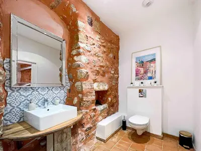 a bathroom with a sink and a stone wall at Apartment Roussillon village Ocre Air conditioning in Roussillon