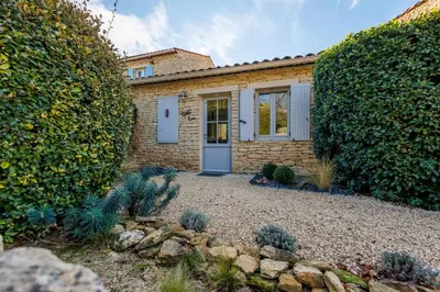 a brick house with a blue door in a yard at Basti Lou - Proche du village de Gordes in Gordes