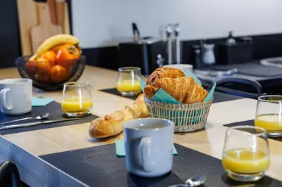 a table with a basket of bread and glasses of orange juice at Basti Lou - Proche du village de Gordes in Gordes