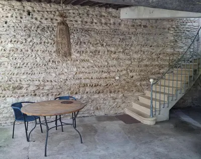 a table and chairs next to a brick wall at La Maison perchée - Mas de Rousseau in Eyragues