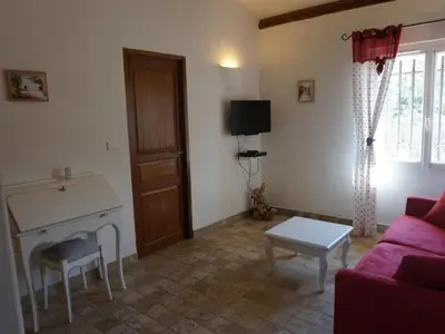 a living room with a red couch and a table at La Buisse in Simiane-la-Rotonde