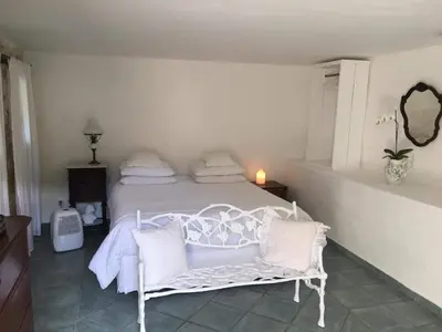 a bedroom with a white bed with white pillows at La Bergerie Pradel in Le Beaucet