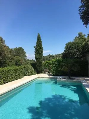 a large blue swimming pool in a yard at La Bergerie Pradel in Le Beaucet