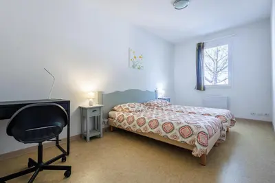 a bedroom with a bed and a desk and a chair at Bastidon Provençal - Avec piscine partagée in Aubignan