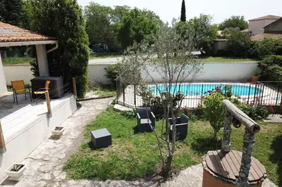 a backyard with a swimming pool and a fence at L'Isle en coeur air-conditioned house with garden and swimming pool in LʼIsle-sur-la-Sorgue