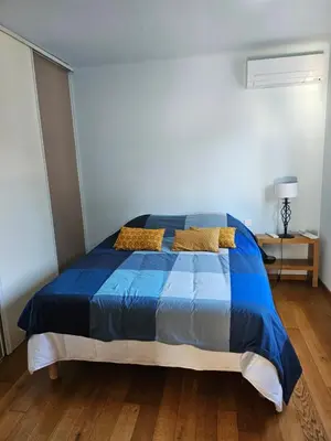 a bedroom with a blue bed with two pillows at Maison au bord de l'eau in Le Thor