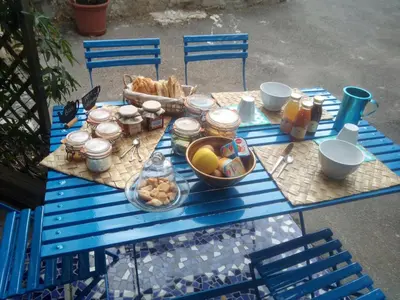 a blue picnic table with a basket of food on it at Gite Fa Mille maison bleu in Robion en Luberon