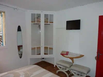 a bedroom with a bed and a table and a tv at Gite Fa Mille maison bleu in Robion en Luberon