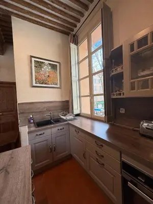 a large kitchen with a sink and a window at Bel appartement aixois dans le centre historique in Aix-en-Provence