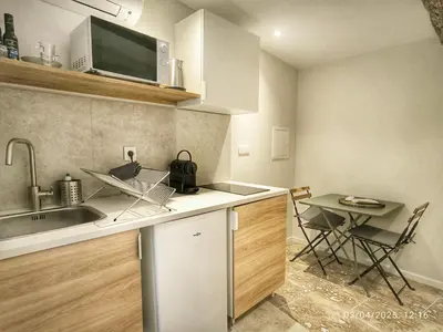 a kitchen with a sink and a table with chairs at Le Solari - Studio lumineux au cœur du centre historique in Aix-en-Provence