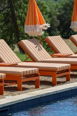a row of lounge chairs with umbrellas next to a pool at Domaine Robert in Rognes