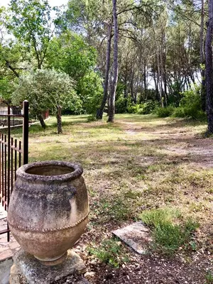 a large stone vase sitting next to a fence at Villa Provençale - Rognes campagne d'Aix en Provence in Rognes