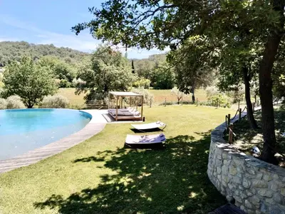 a swimming pool in a yard next to a stone wall at Villa Provençale - Rognes campagne d'Aix en Provence in Rognes